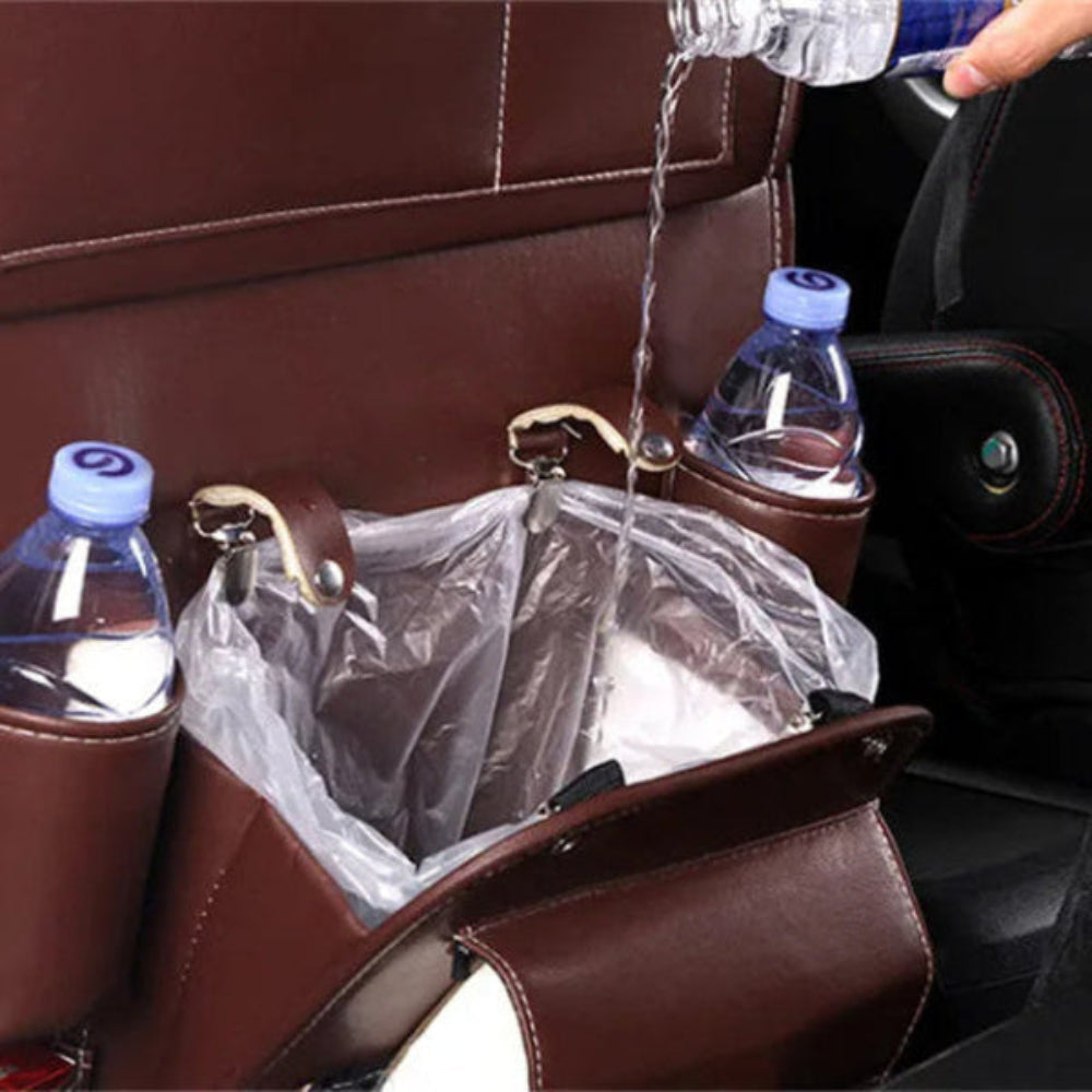 Close-up of the brown seat-back organizer’s lined trash pocket as water is poured in, with drink bottles in the side holders.